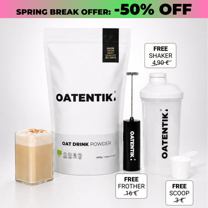 Oat drink powder package with a glass of oat milk, free shaker, frother, and scoop on a white background.
